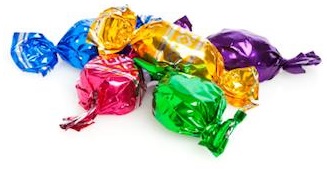 Five candies wrapped in colored foil on white background